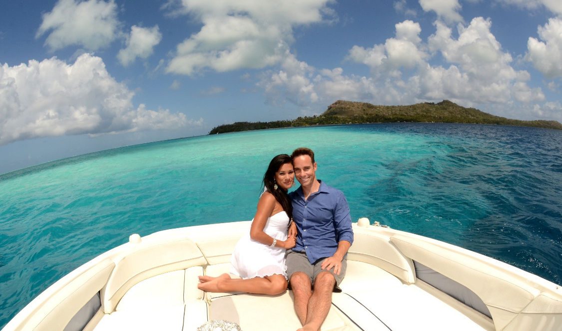 couple photoshoot enjoying private lover cruise in bora bora during their vacation