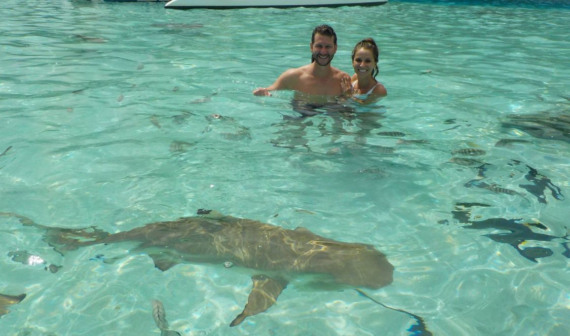 couple posing with sharks at jetski tour in moorea during vacation