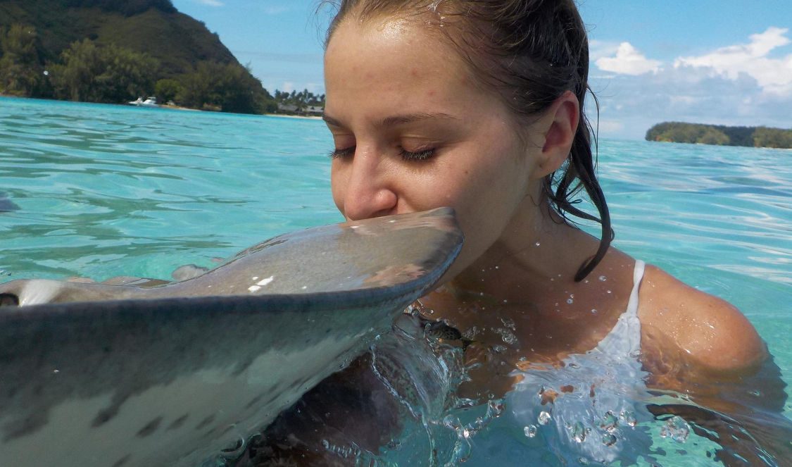 girl kissing a ray during jetski tour in Moorea French Polynesia