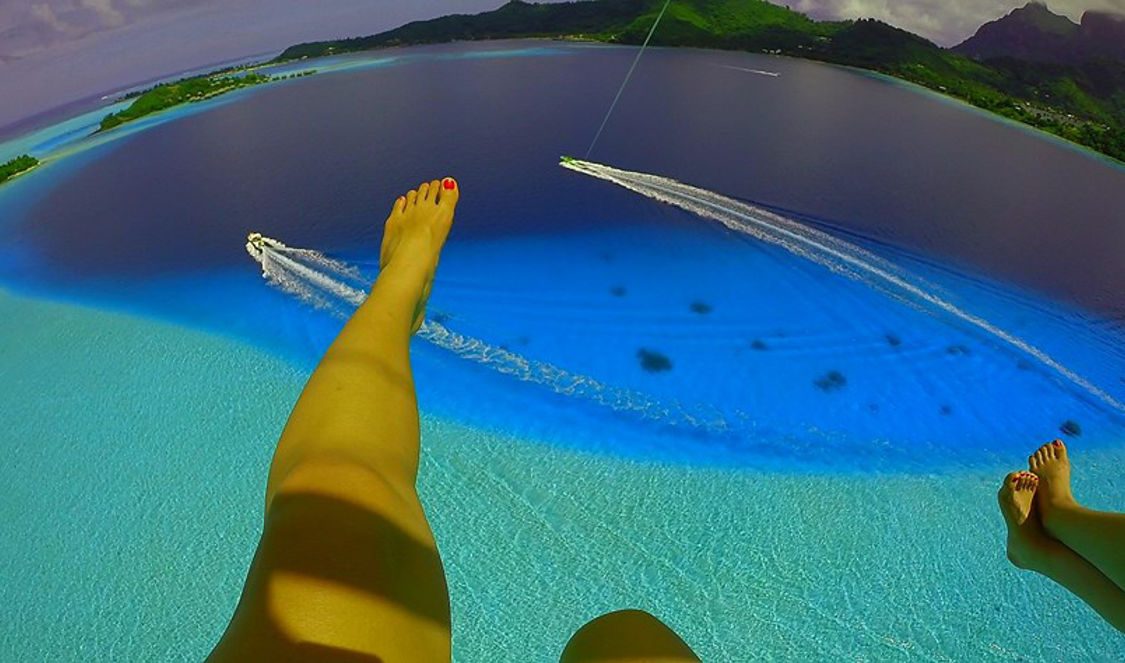 girls parasailing over bora bora famous lagoon during their holiday