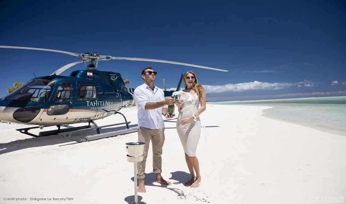 couple après tour privé en hélicoptère à Bora Bora, buvant du champagne sur une plage déserte durant leur voyage en polynésie